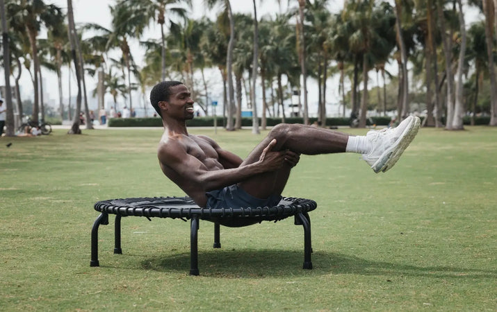 Man doing advanced core exercise on JumpSport trampoline